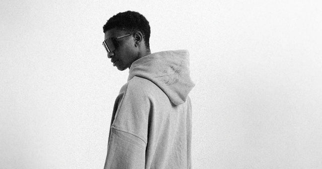 Ein junger Mann trägt einen oversized Hoodie von Favela Clothing und kreiert seinen eigenen Urban Style