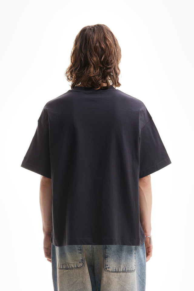 Back view of a model who wears a black vintage overzised T-Shirt 