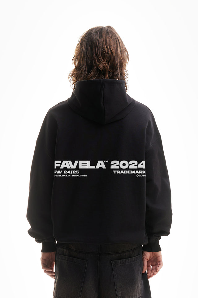 Model trägt einen black washed oversized hoodie mit favela 2024 backprint