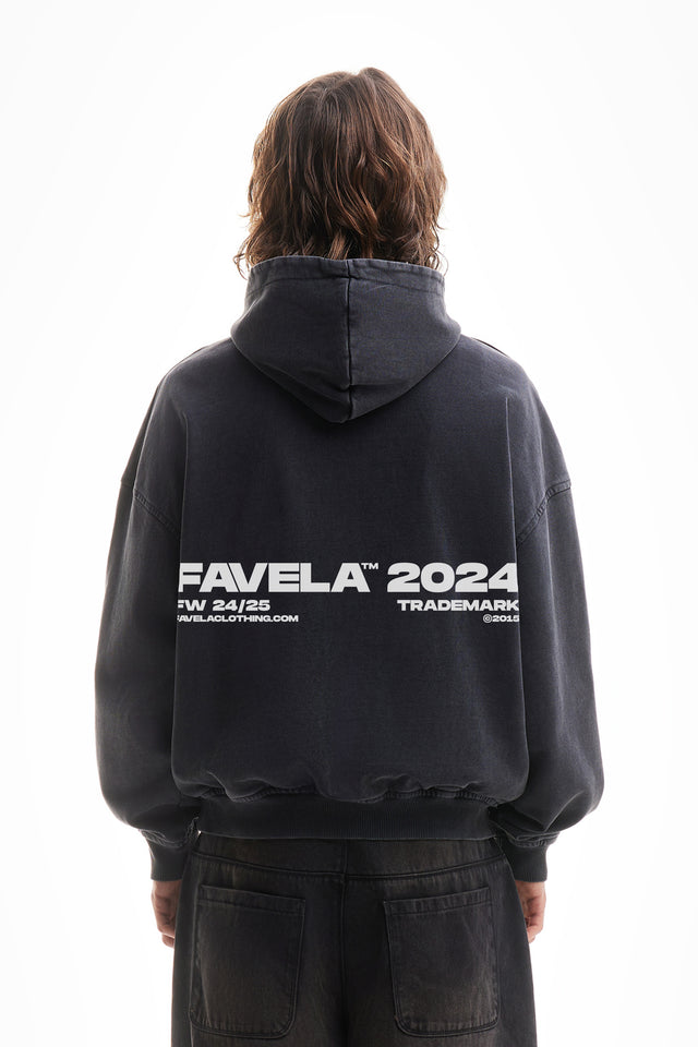 Model trägt einen black washed oversized hoodie mit favela 2024 backprint