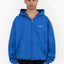 Model trägt royal blue frontzip hoodie mit oversized fit und favela logo auf der brust