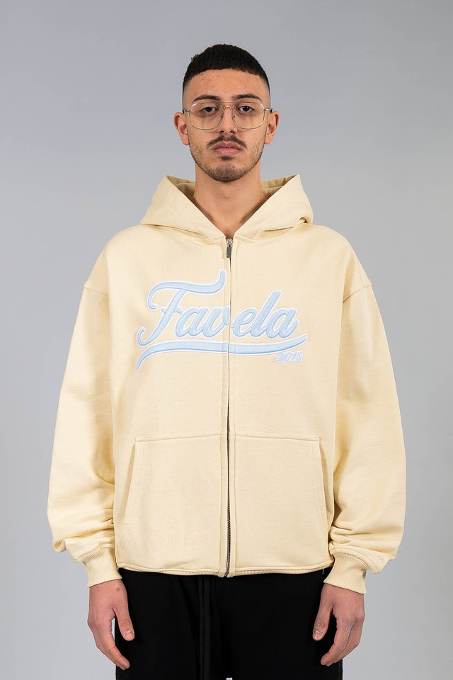 Favela Clothing Model trägt den Creme Zip Hoodie. 